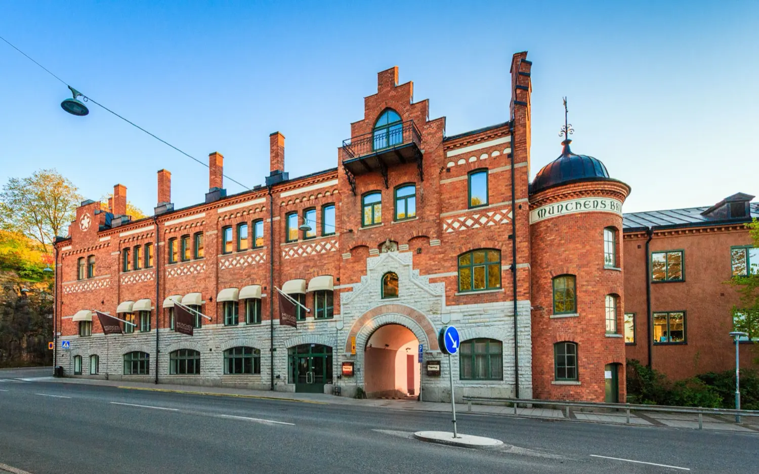 Münchenbryggeriets tegelfasad i kvällssol, med namnet murat i fasaden