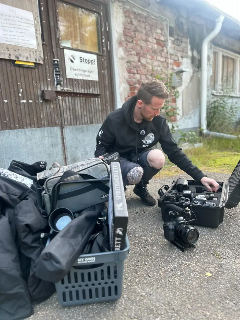 Kim pakker kameraer og måleudstyr ud uden for sanatoriets bagdør